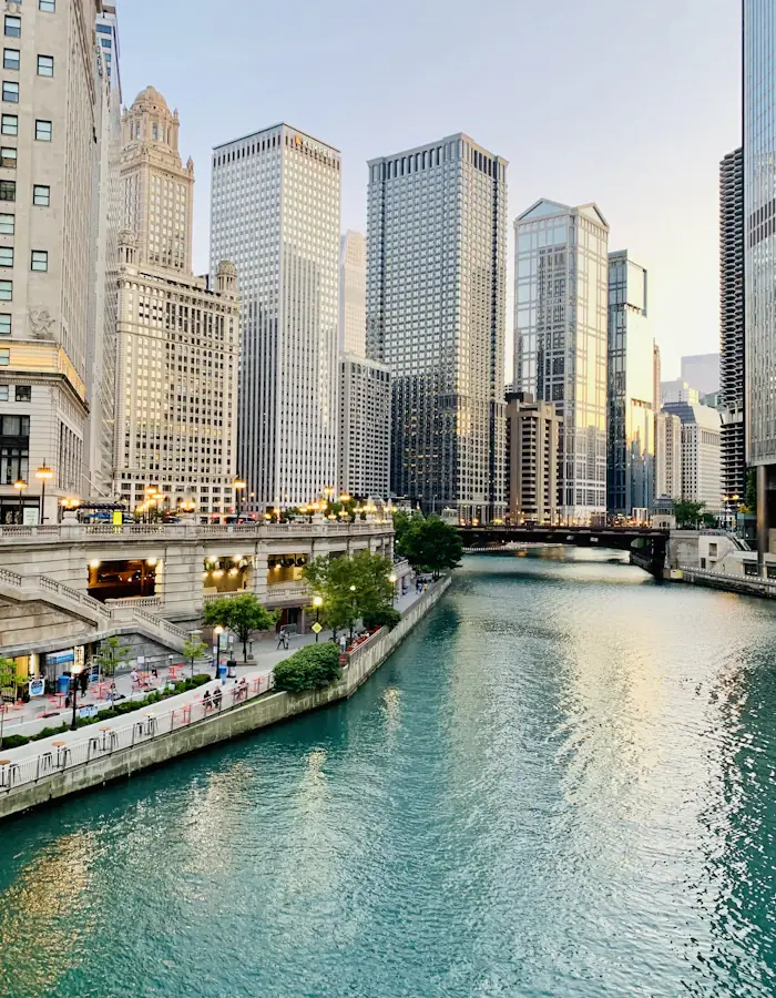 A couple walking the Chicago Riverwalk beneath the bridges at dusk
