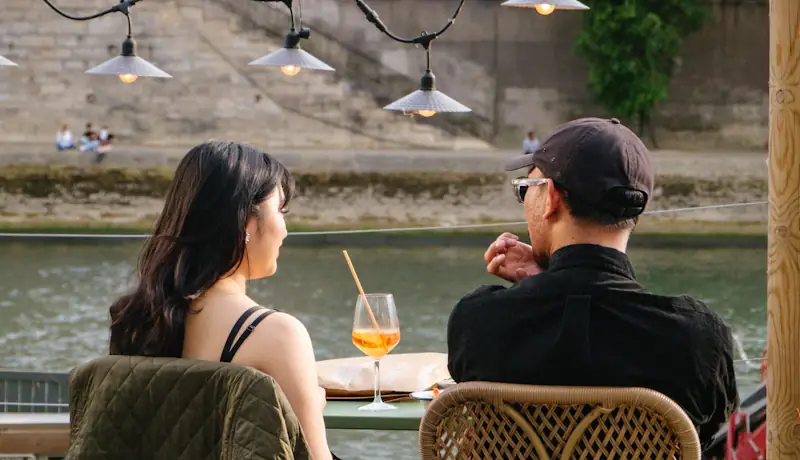 Two people in conversation at a riverside café table in Chicago