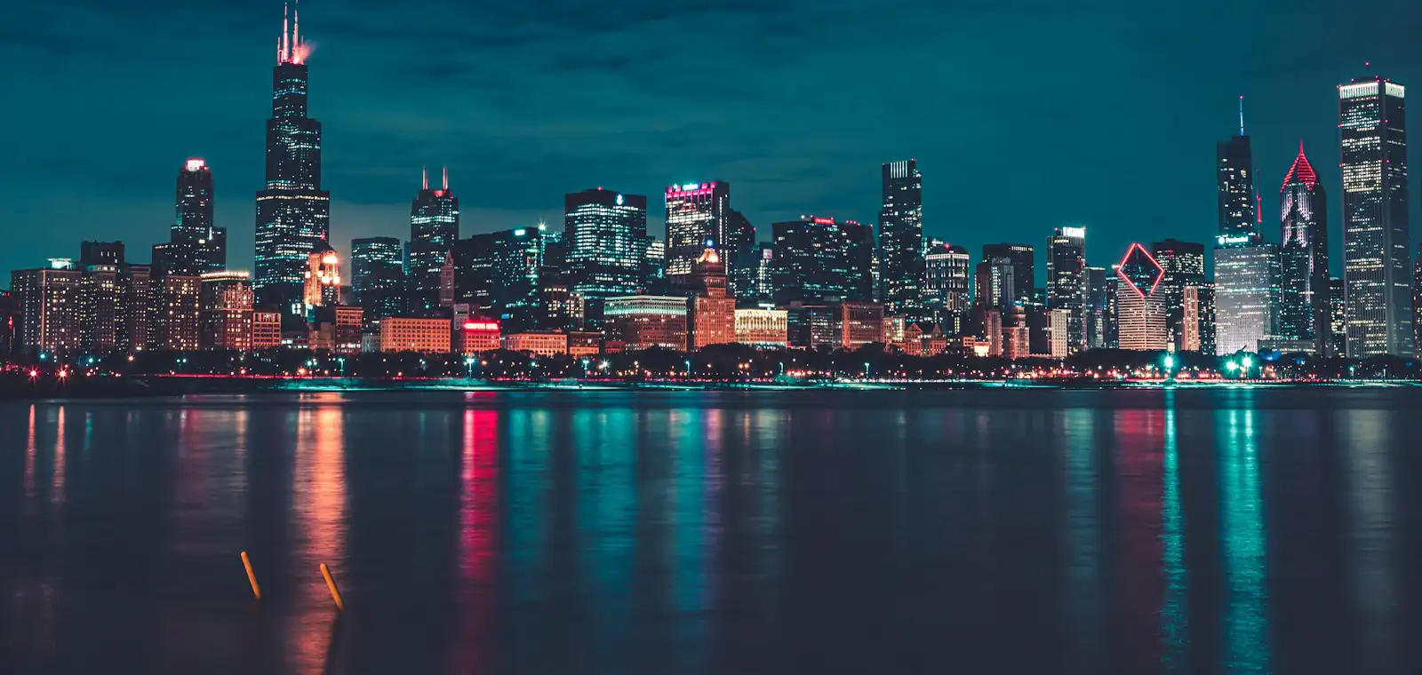 Chicago high-rises lit from within against a deep blue evening sky